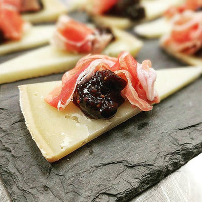 Figs and Black Tea with prosciutto on a piece of gruyere cheese